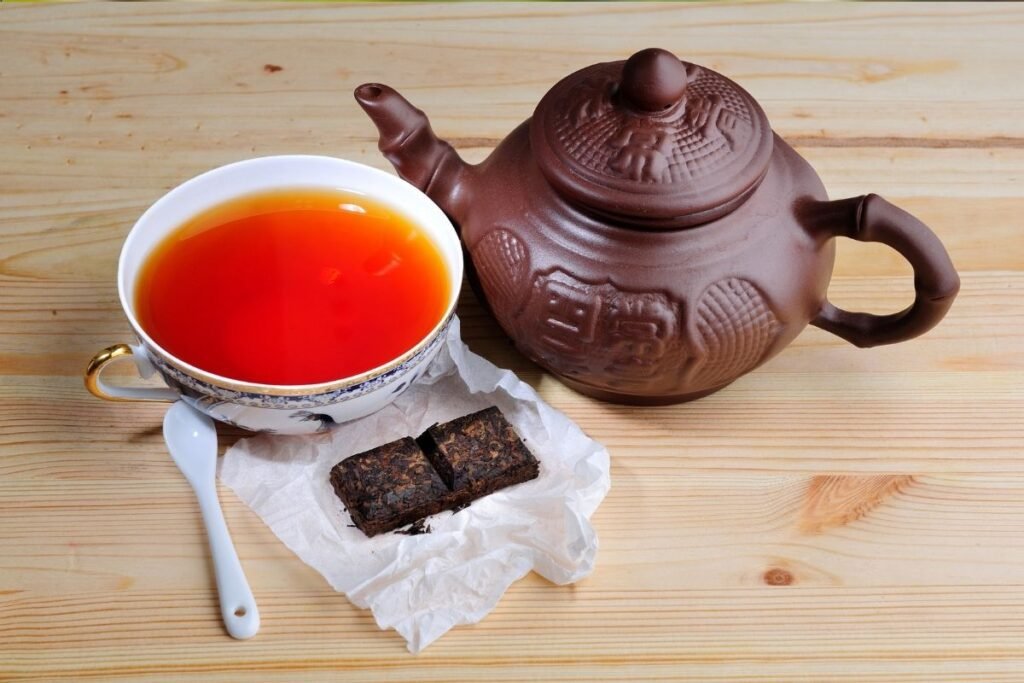 Ceai Pu-erh în cană de porțelan și ceainic tradițional chinezesc din lut. Beneficiile ceaiului Pu-erh